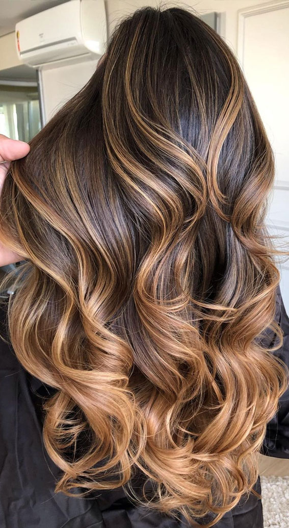 Golden brown wavy hair with copper and caramel blended highlights