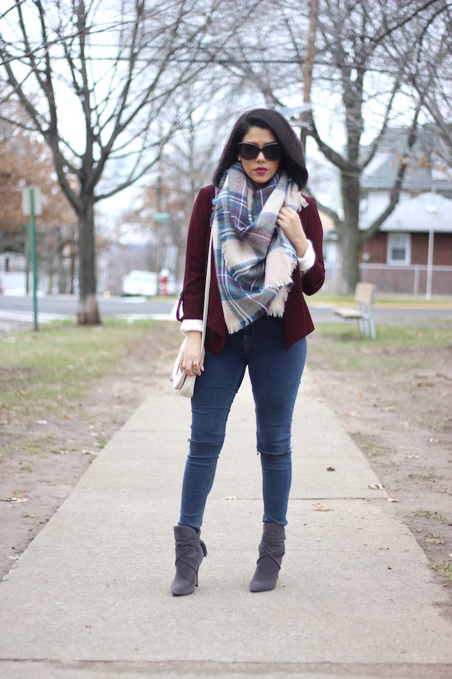 Woman wearing an oversized blanket scarf with jeans and boots