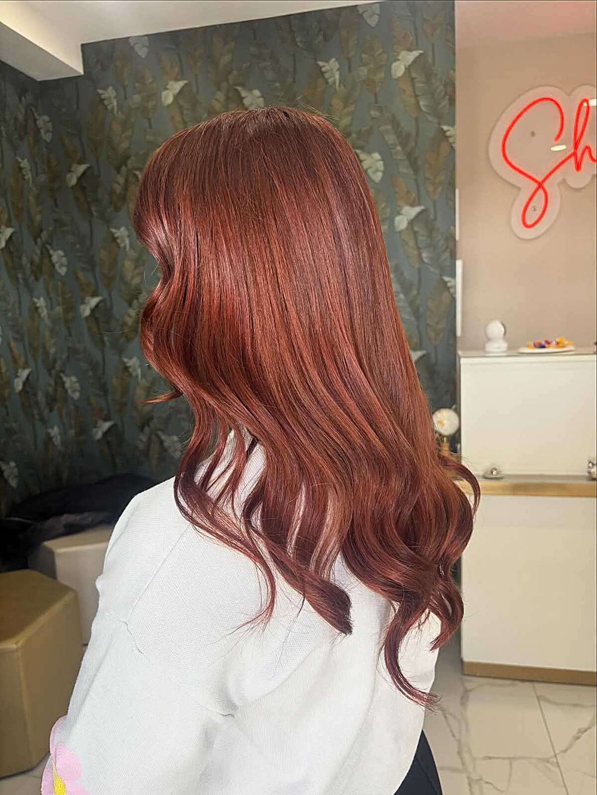 Mid-length waves in burnished cinnamon red-brown hair color