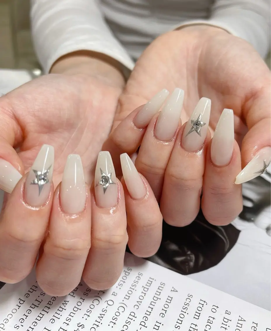 Soft ivory white nails with a silver star accent