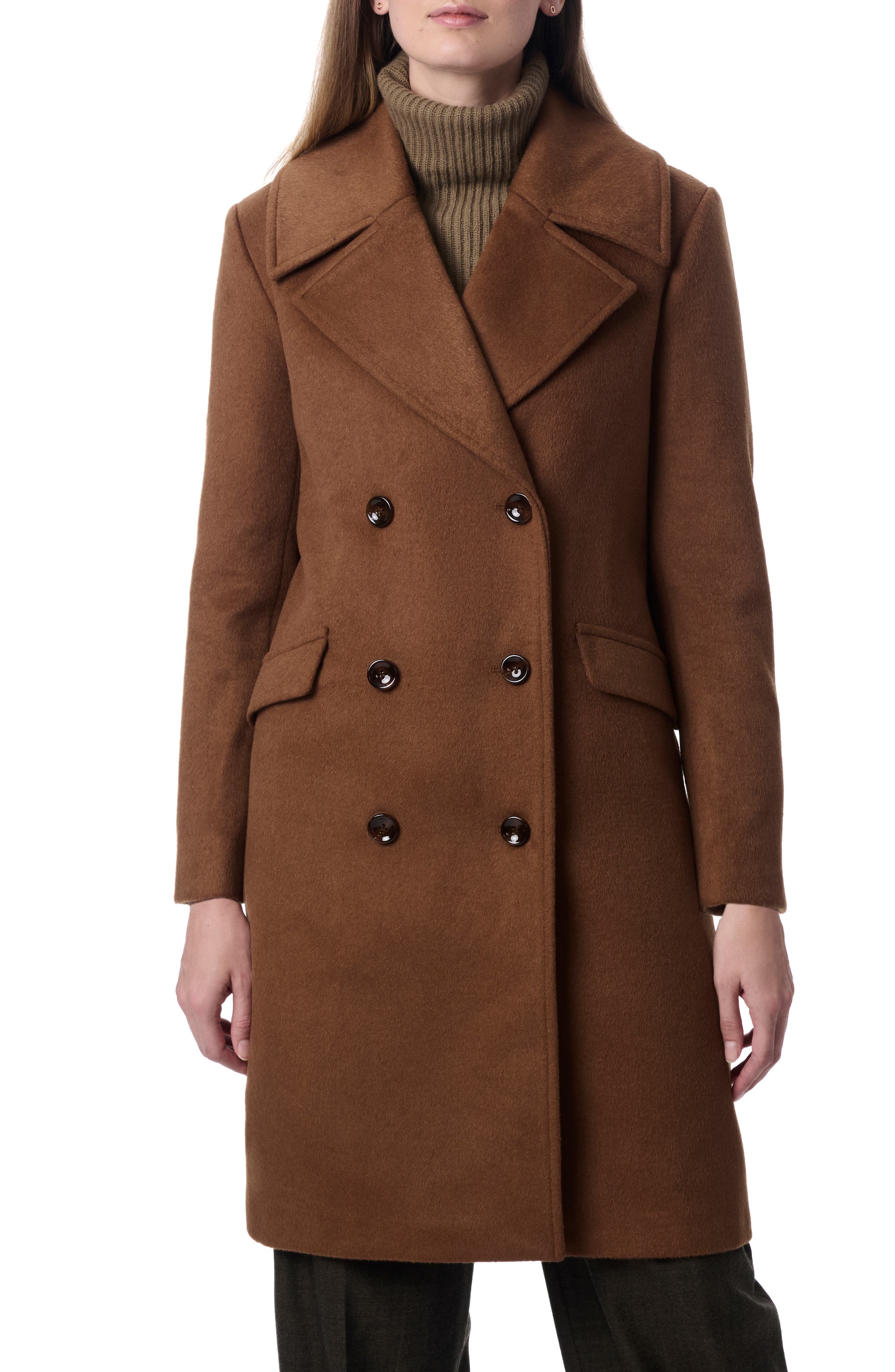 A chestnut brown double-breasted long coat over an olive green turtleneck and dark trousers.