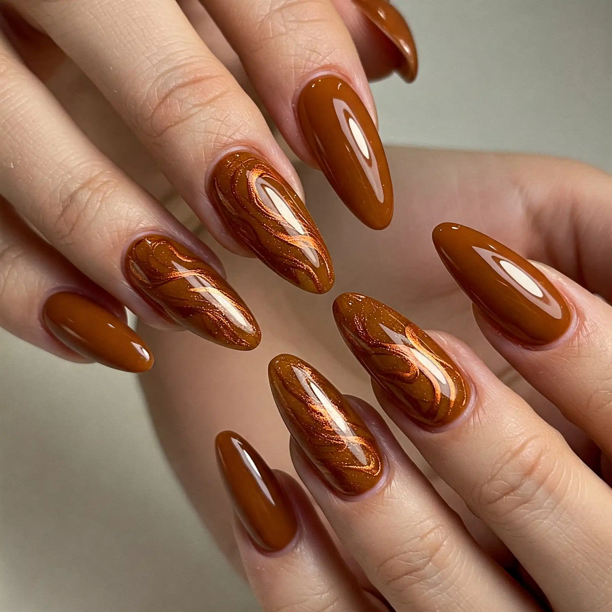 Glossy caramel brown nails in an almond shape