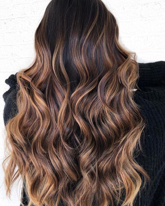 Long dark hair with warm caramel balayage melting from dark roots