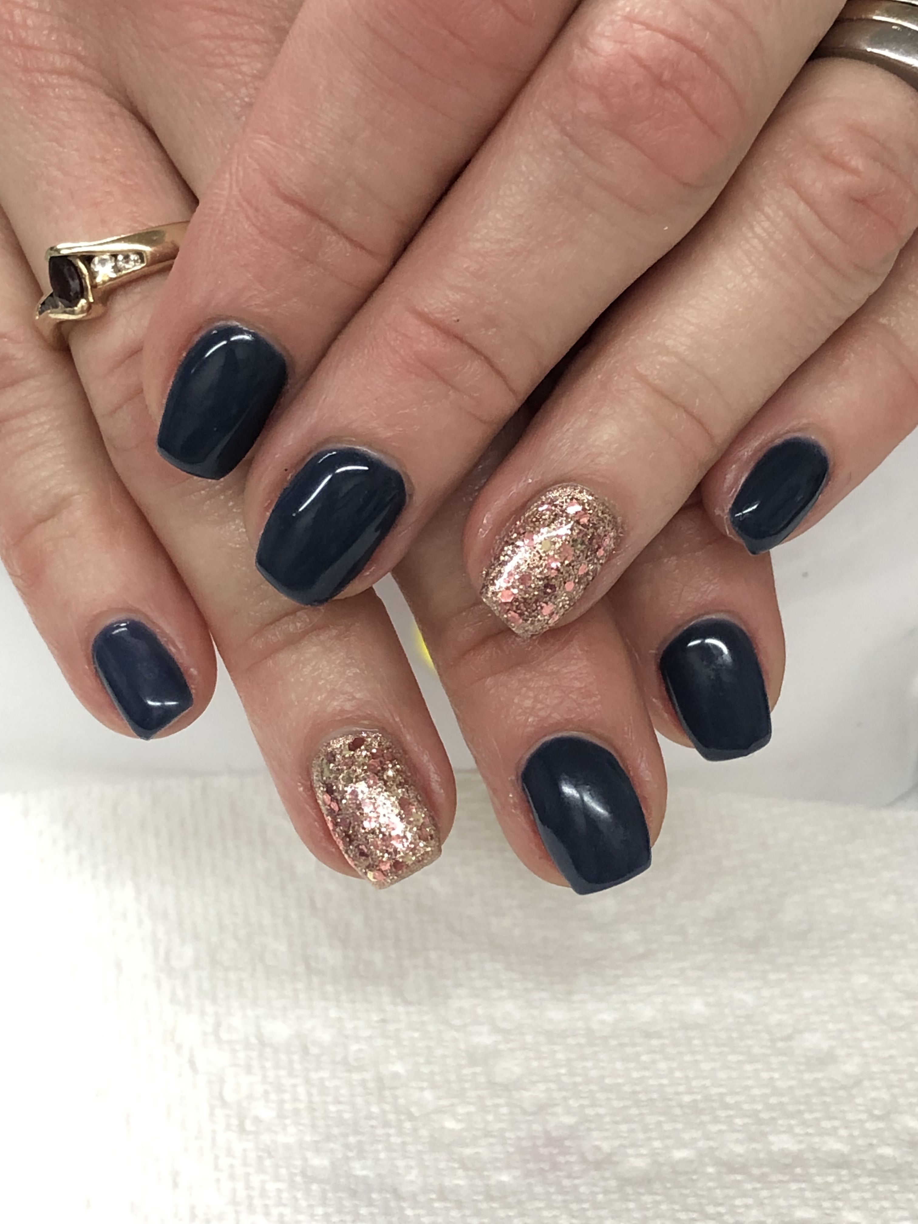Short squoval navy nails with rose gold glitter accent nails