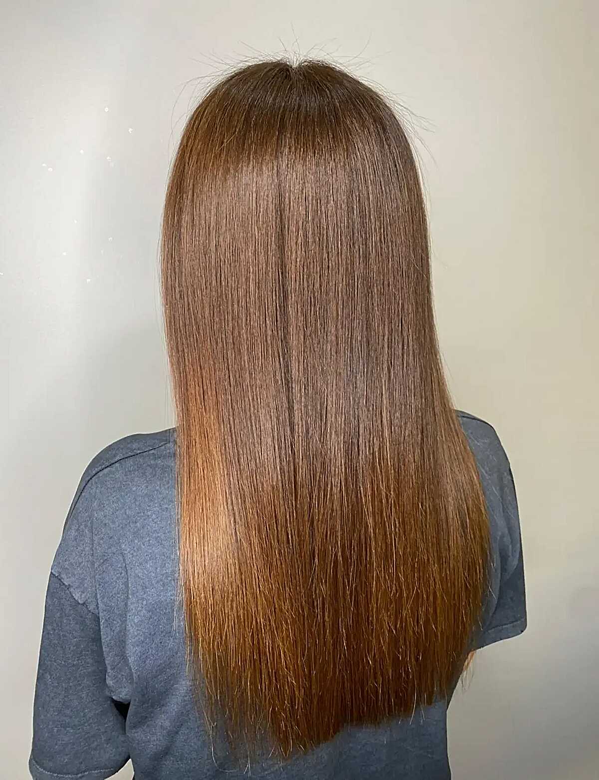 Long straight hair melting from chestnut brown into copper ends
