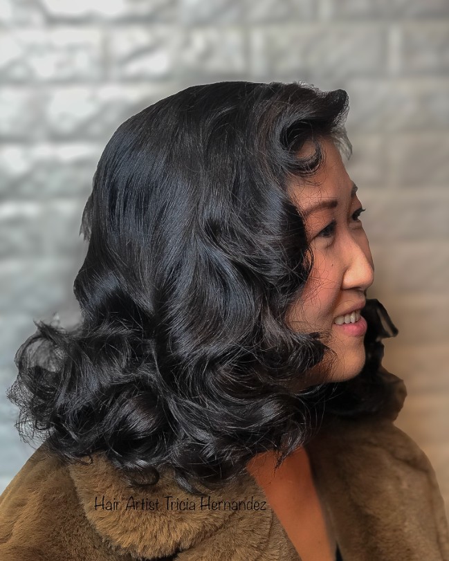 Glossy ebony black retro waves with a deep side part and flowing volume