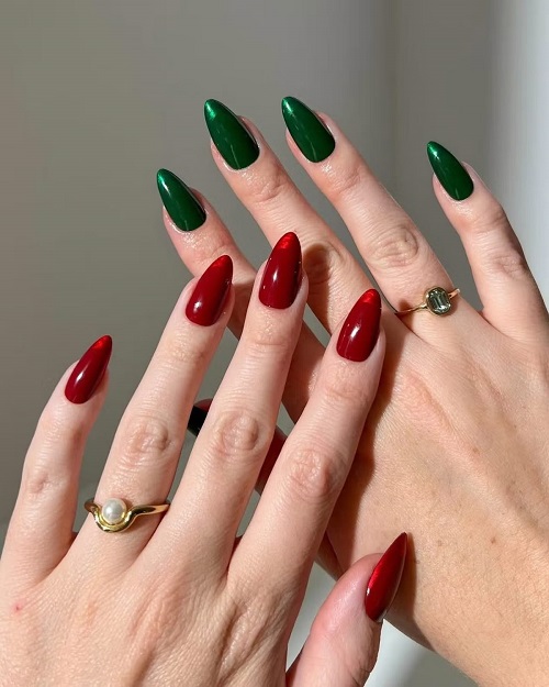 Alternating glossy deep red and forest green solid nails on long almond nails