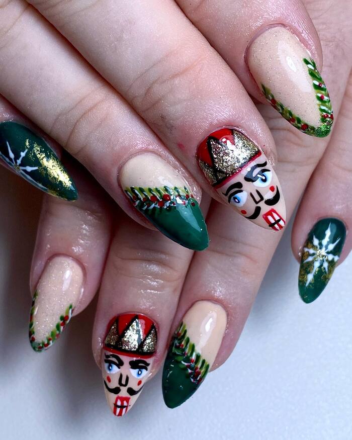 Nutcracker soldier nail art with green garland tips and deep green Christmas nails
