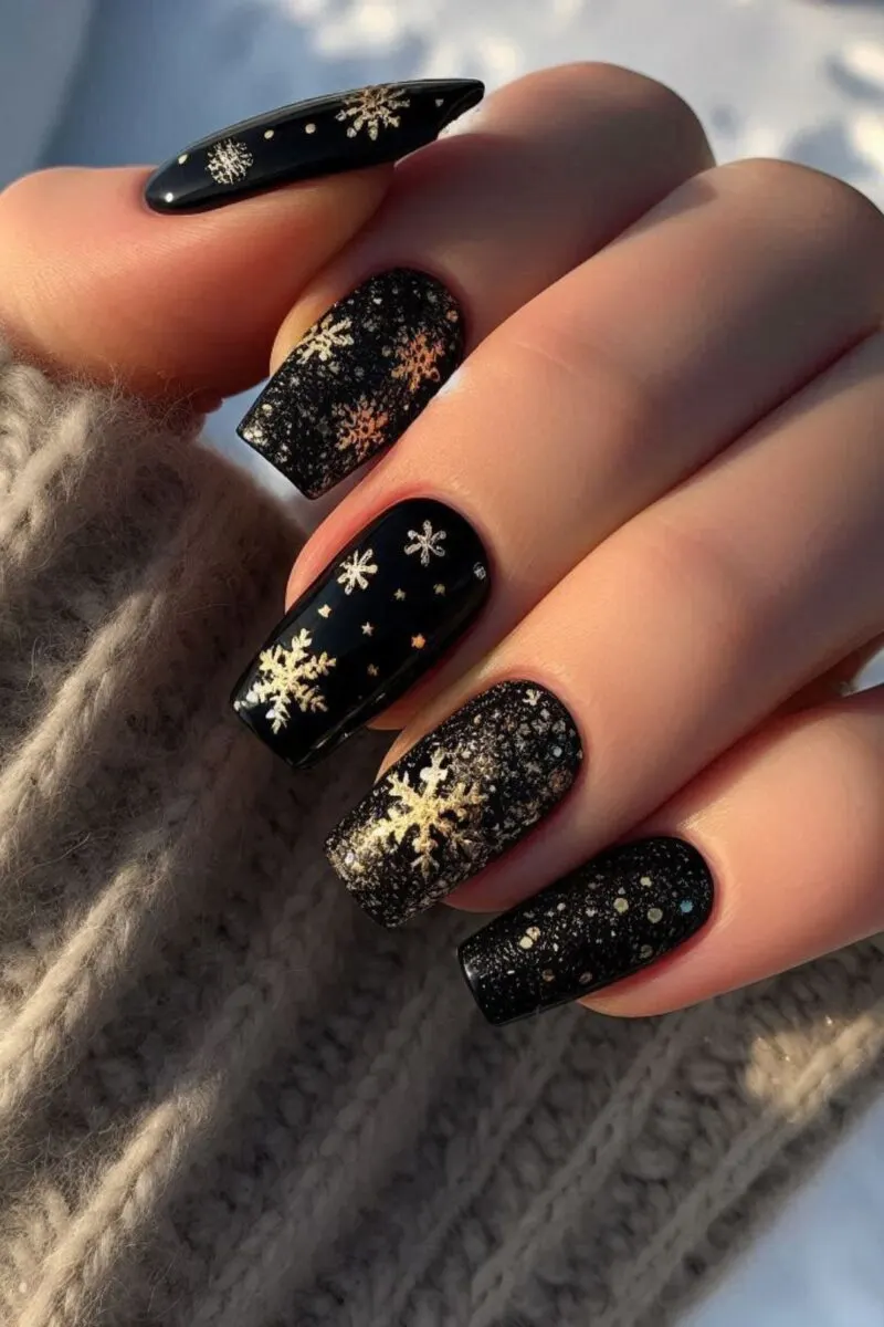 Black oval nails with gold snowflake glitter nail art