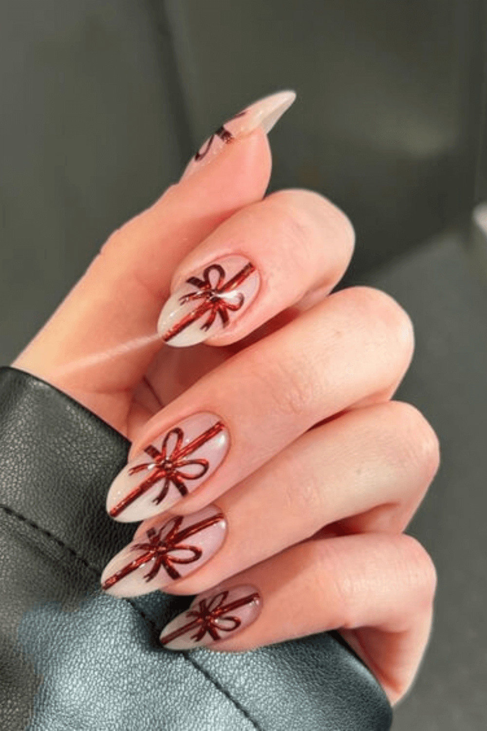 Short almond milky white nails with red metallic gift-bow line art on every nail