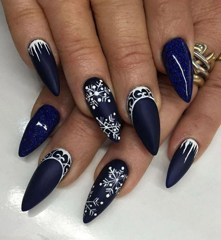 Deep navy stiletto nails with white snowflakes, icicle art and glitter accents