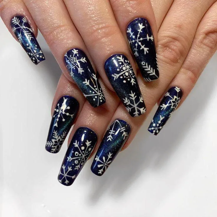 Navy blue almond nails with white snowflake nail art