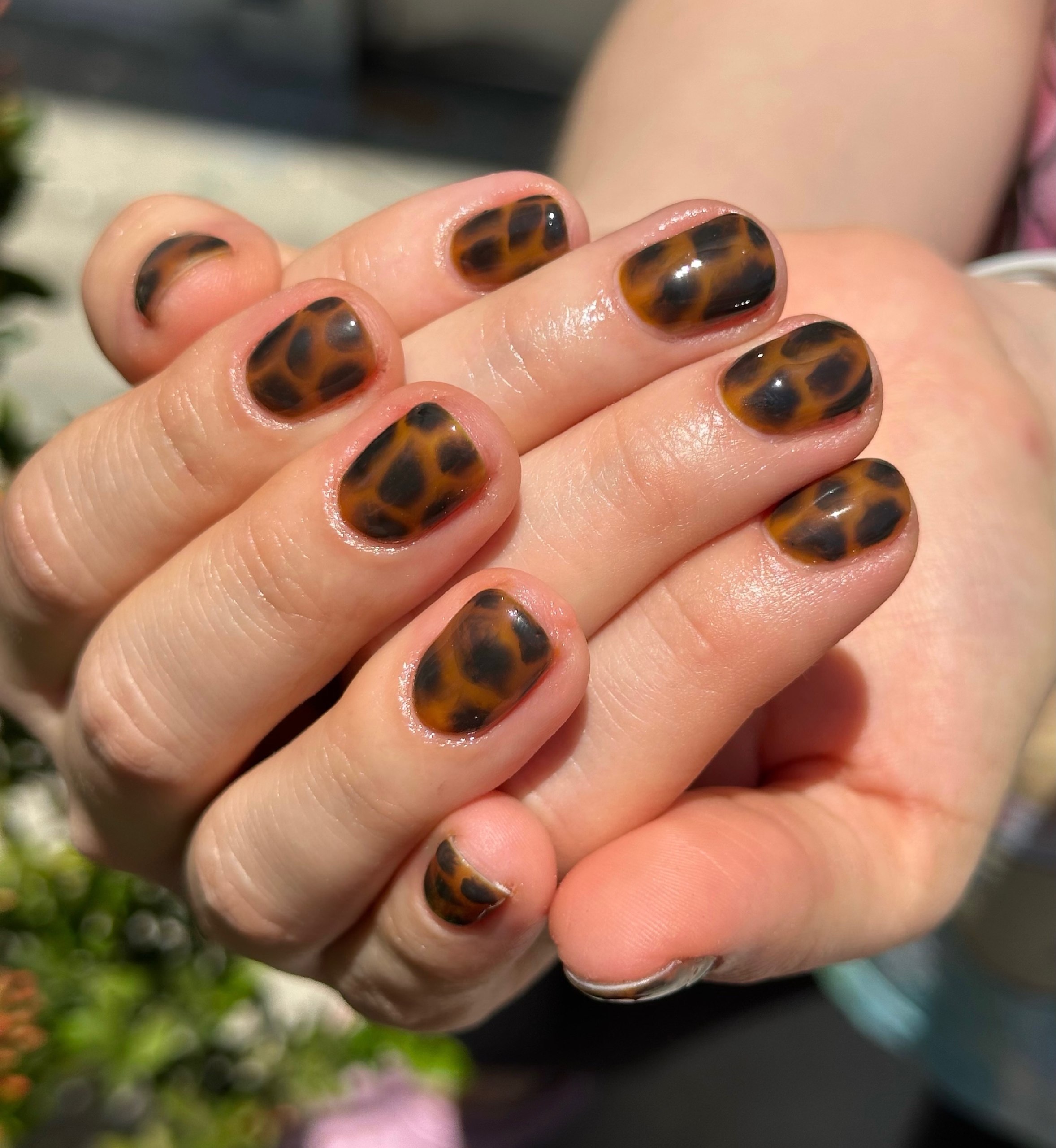 Short nails with a warm amber and brown tortoiseshell pattern