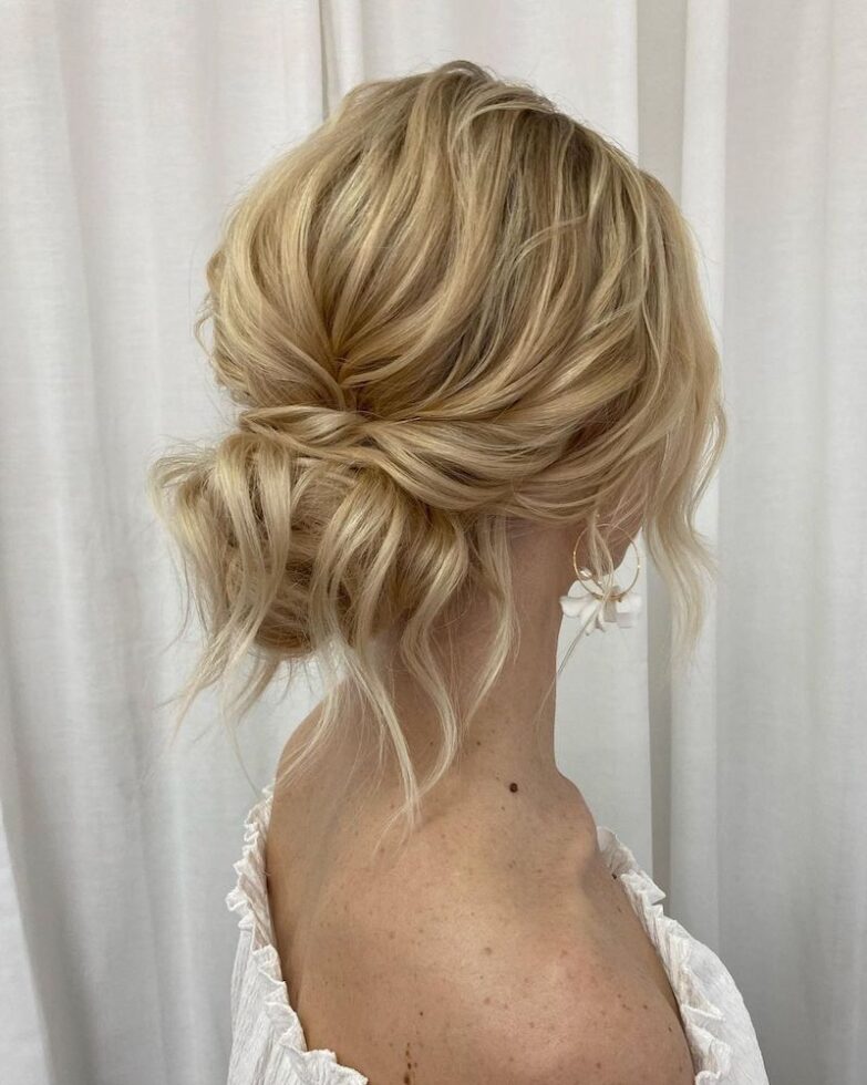 Loose low chignon with textured finish and soft wispy ends