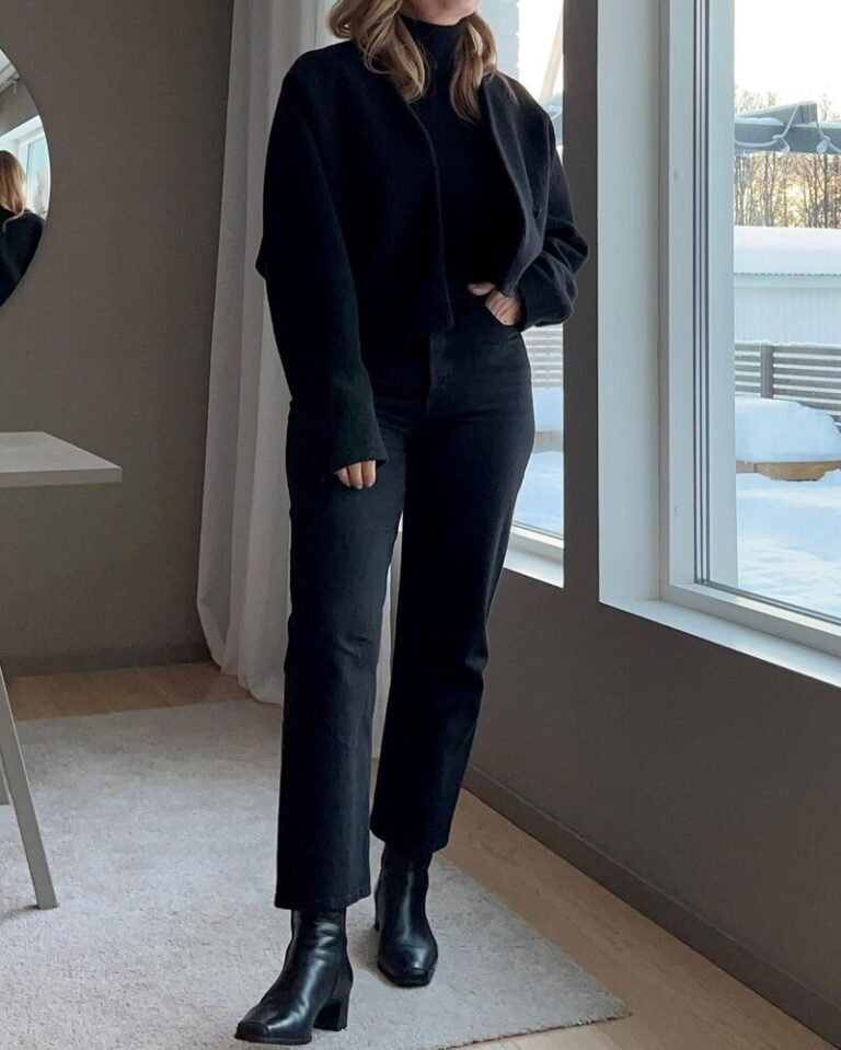 Woman in a black turtleneck, black jeans and ankle boots in a minimalist winter look