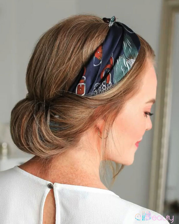 Woman with a low twisted chignon wearing a printed silk scarf as a headband