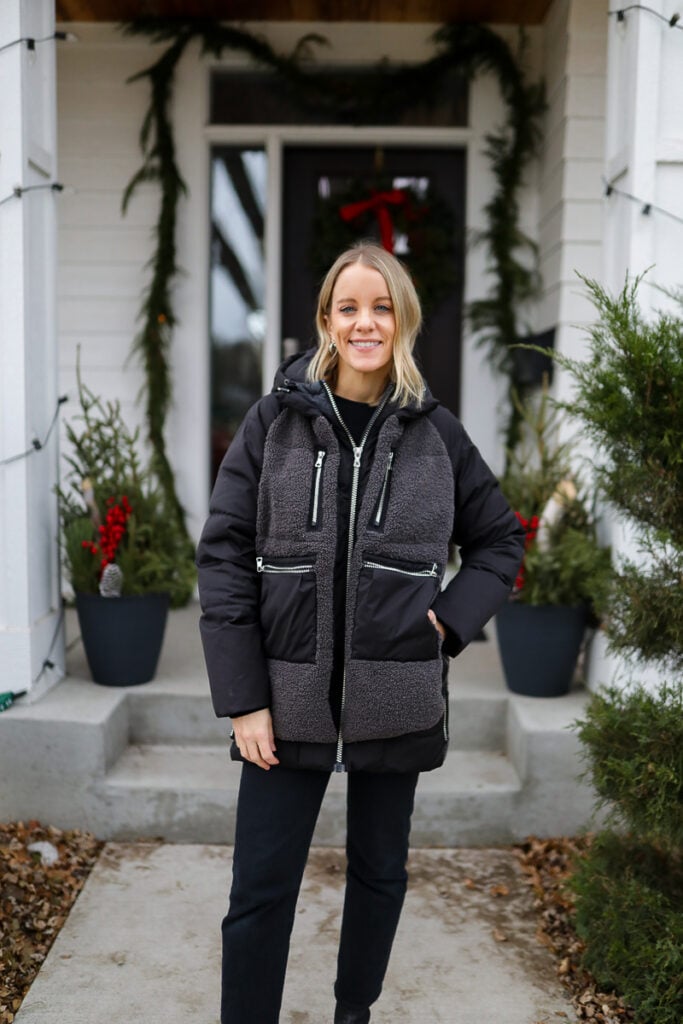 Woman wearing a black sherpa-panel puffer jacket with black jeans
