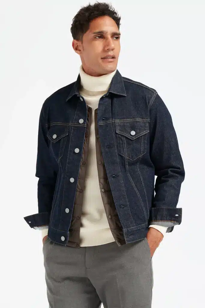 Woman layering a turtleneck sweater under a denim trucker jacket