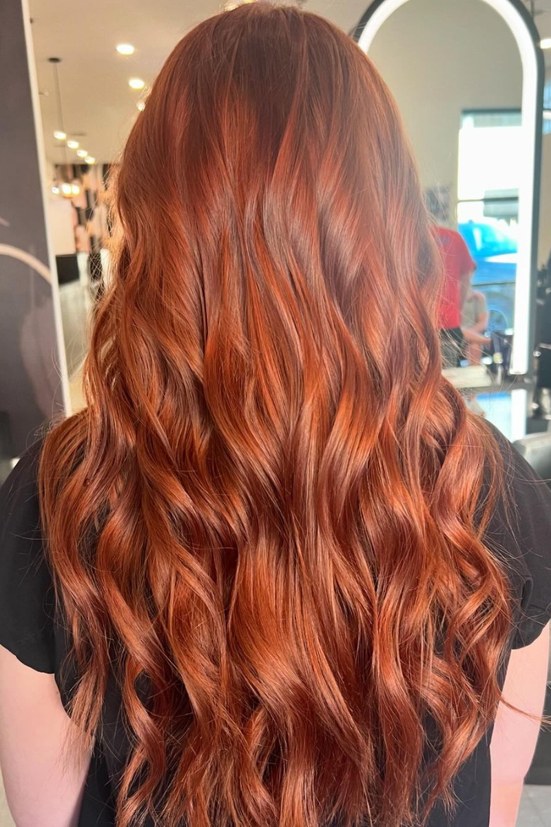 Copper balayage on long hair styled in loose beach waves