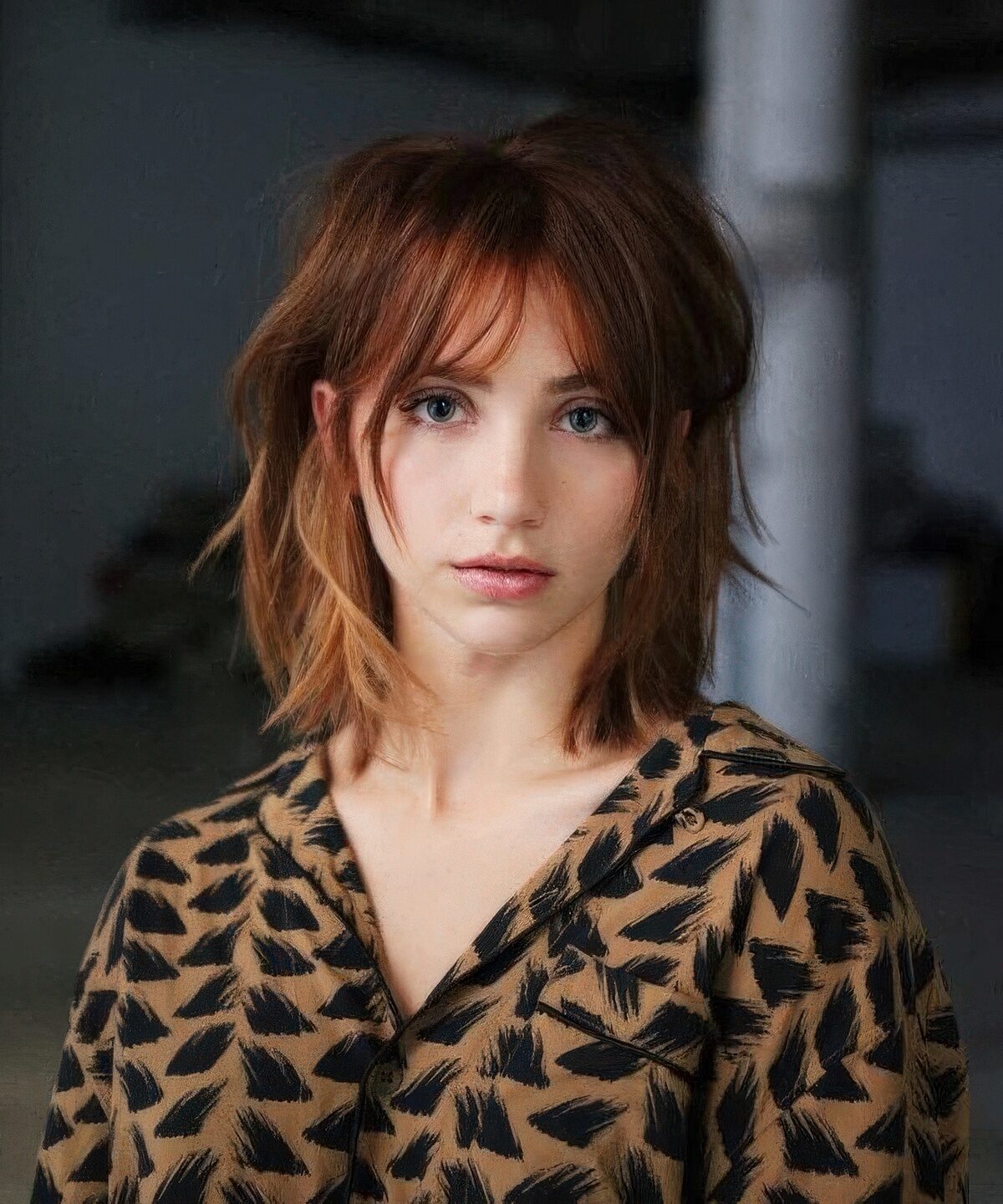 Woman with copper red medium-length layered hair and bottleneck bangs
