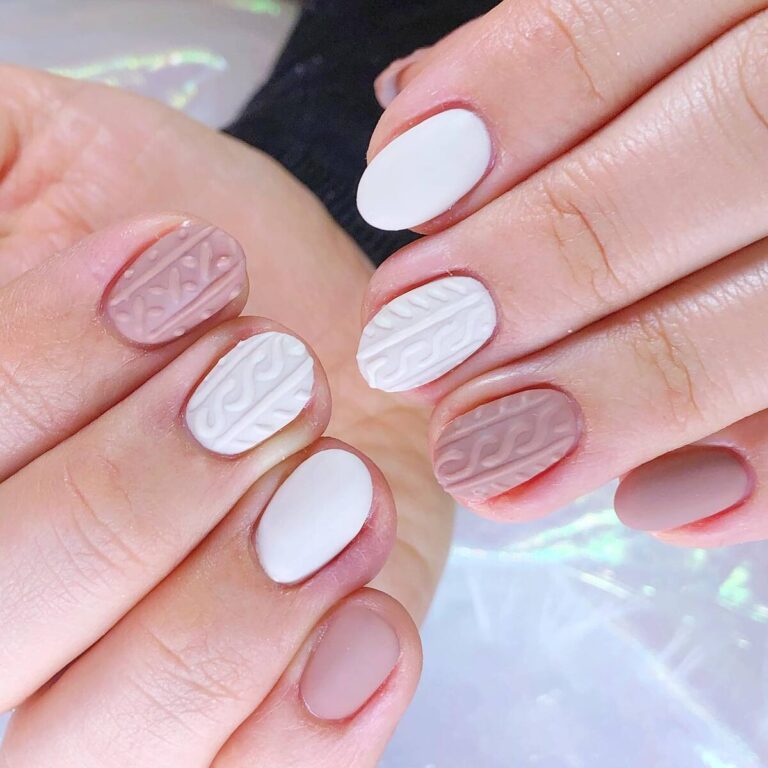 Short oval nails with matte white and dusty rose cable-knit texture