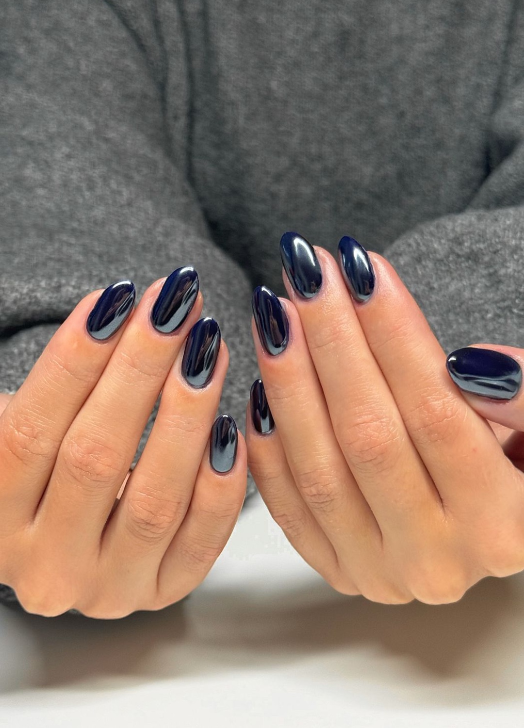 Almond nails in dark navy blue with chrome mirror finish