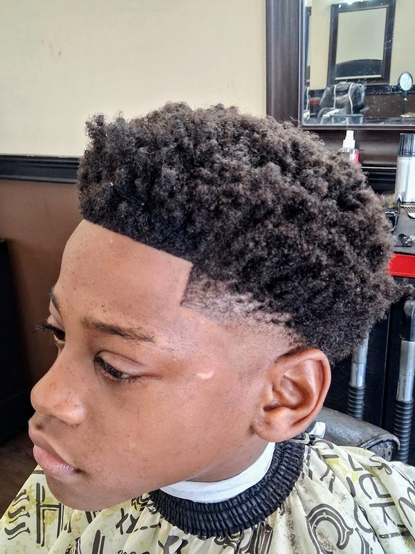 Young Black boy with a curly tapered crop and clean shape-up