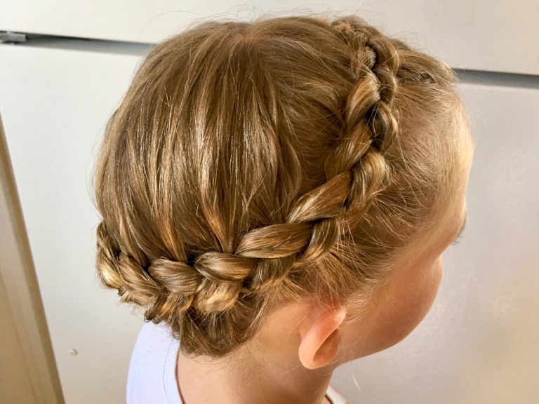 Young girl wearing a crown halo braid wrapped around her head (photo credited to Ms. Joanna's Kids Salon)