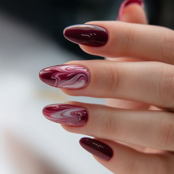 Short oval plum nails with white marble swirl accents