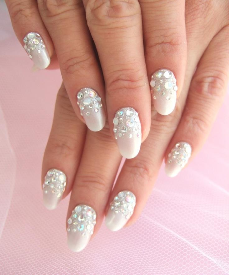 Ivory nails with rhinestone crystal clusters near the cuticles on oval nails