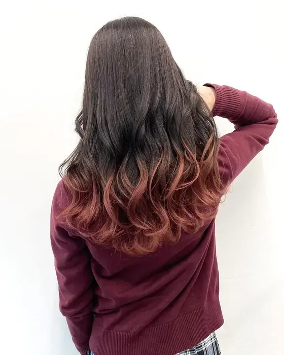 Shoulder-length terracotta copper hair with a soft side part