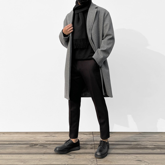 Man wearing a tailored winter coat with slim layered outfit