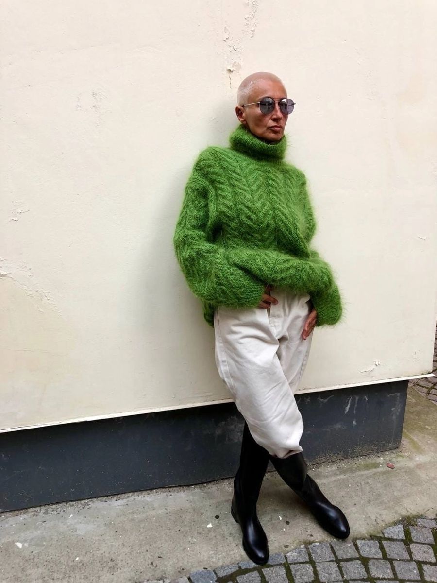 Woman in an emerald green knit sweater with a dark skirt