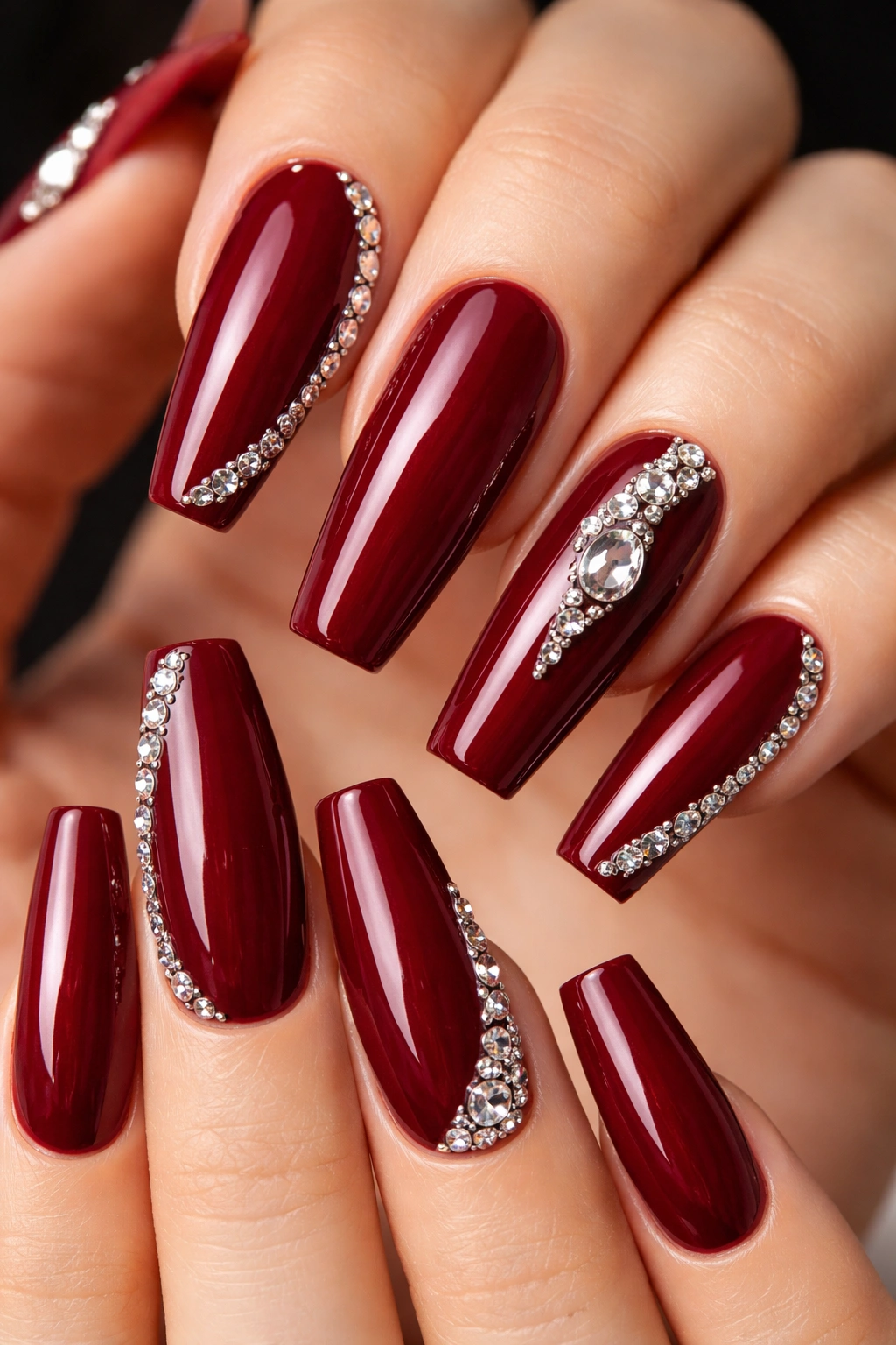 Dark red nails with rhinestone accents