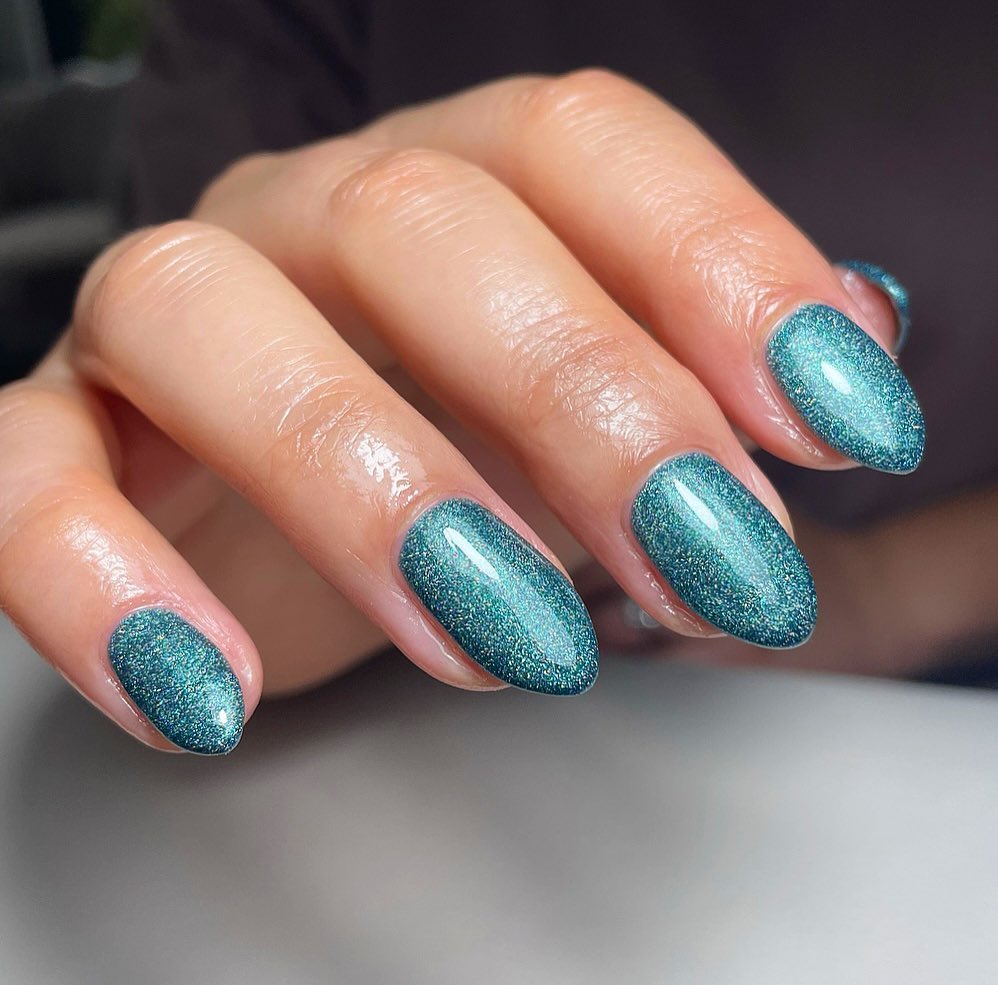 Short oval nails in teal glitter polish
