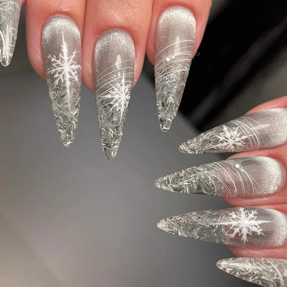 Long silver chrome stiletto nails decorated with white snowflake decals and fine line art