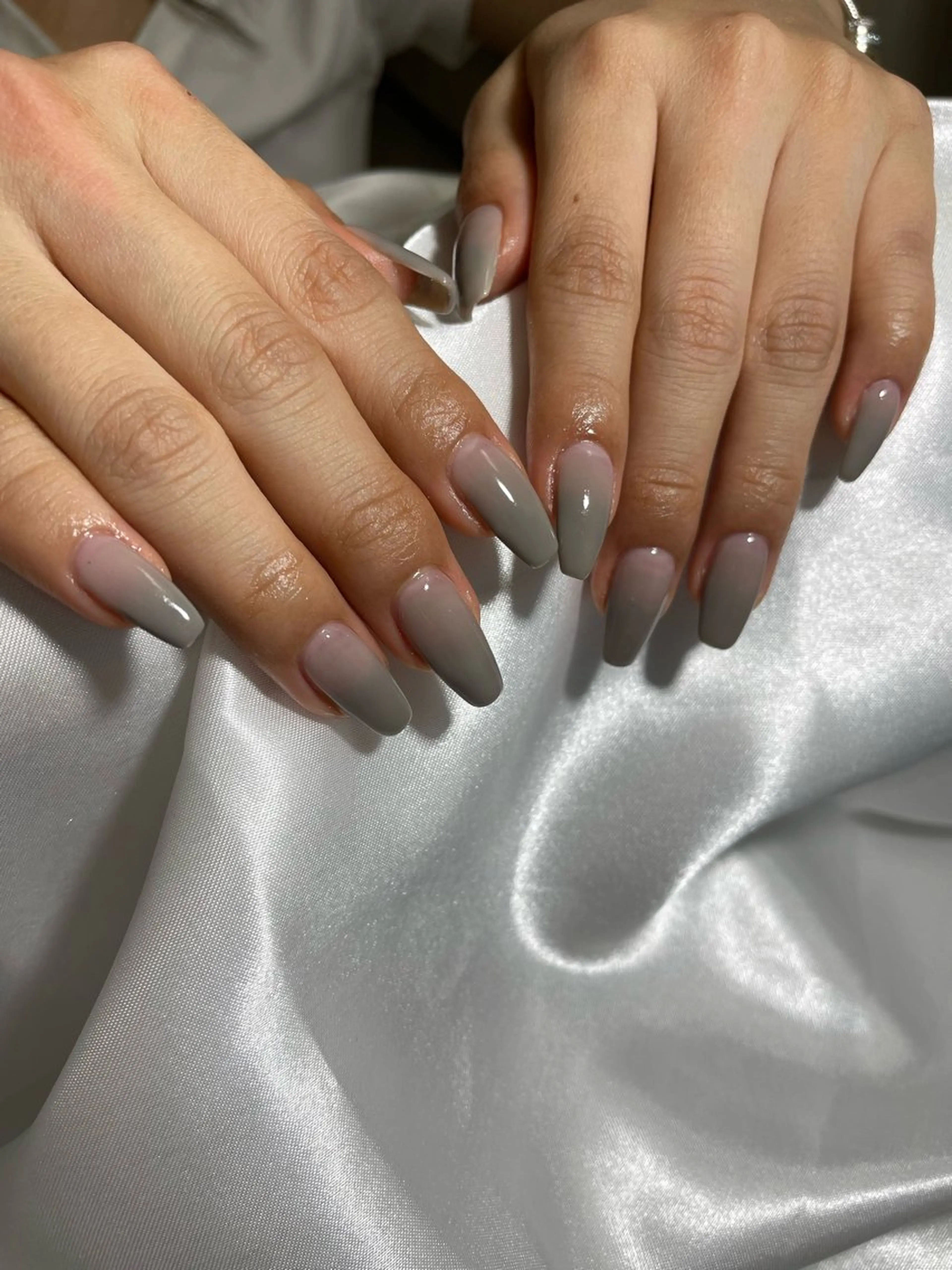 Long coffin nails in glossy nude-to-gray baby-boomer ombre