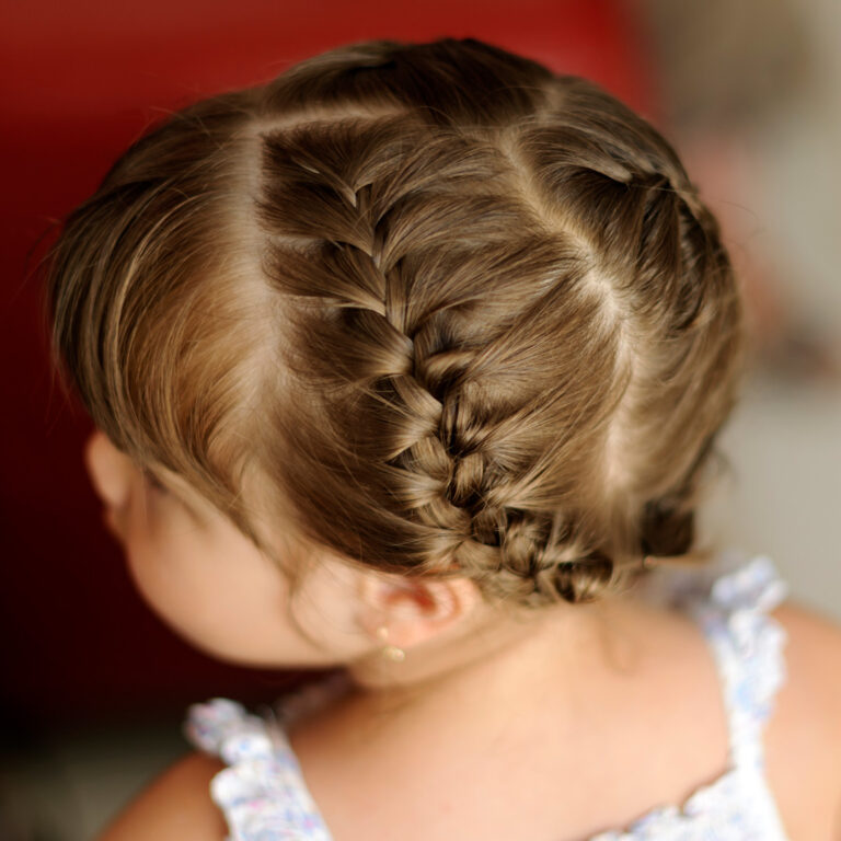 Back view of a little girl's double dutch braids gathered into a low bun
