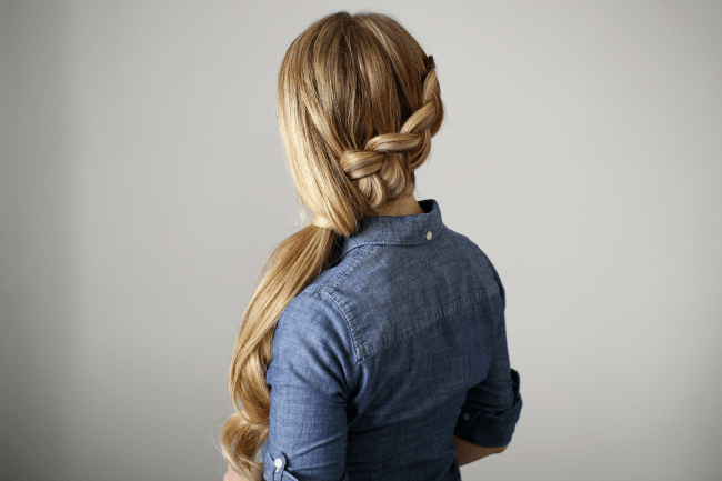 Side-swept Dutch braid into a low ponytail