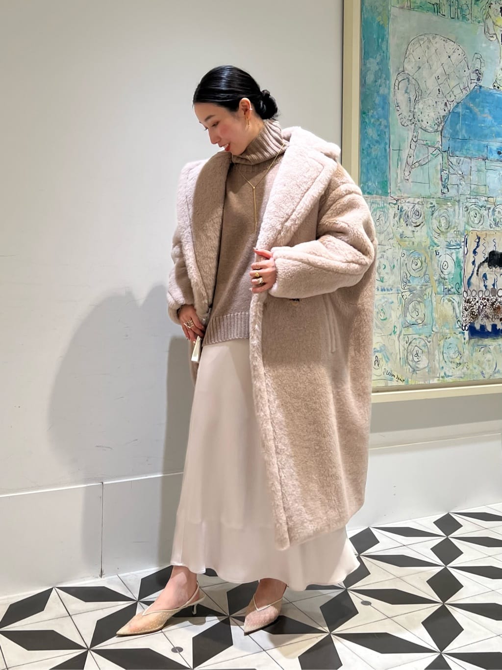 Beige faux fur coat worn open over a camel turtleneck and champagne satin slip skirt