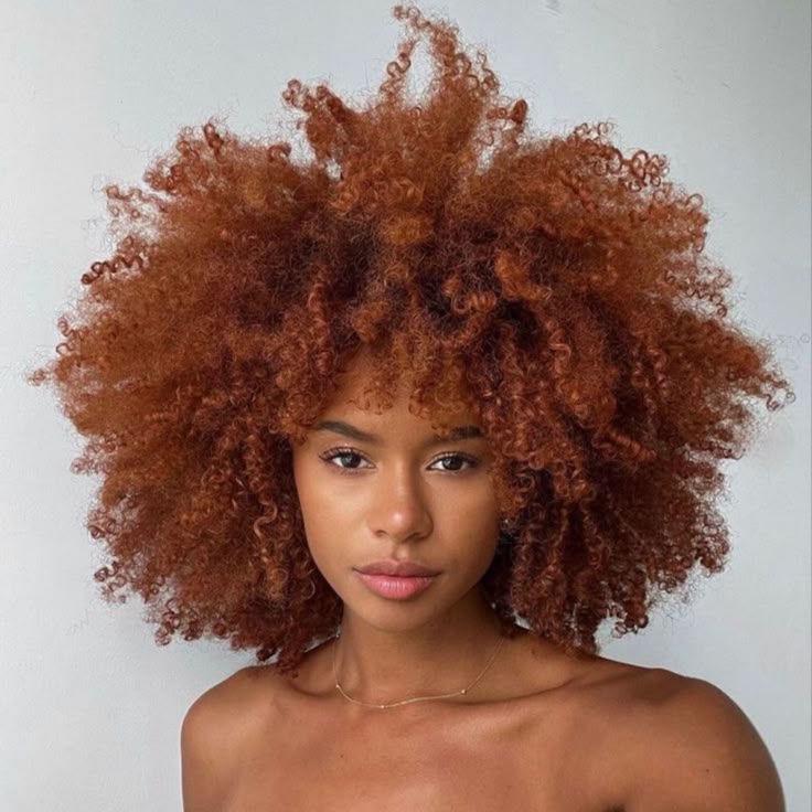 Auburn copper voluminous curls on a Black woman