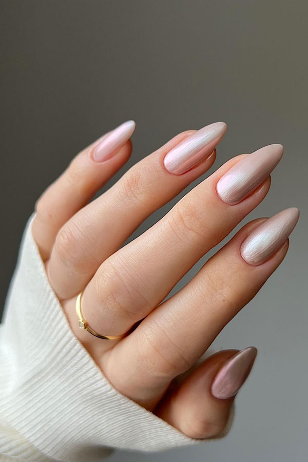 Pearlescent pink polish on elegant almond-shaped nails