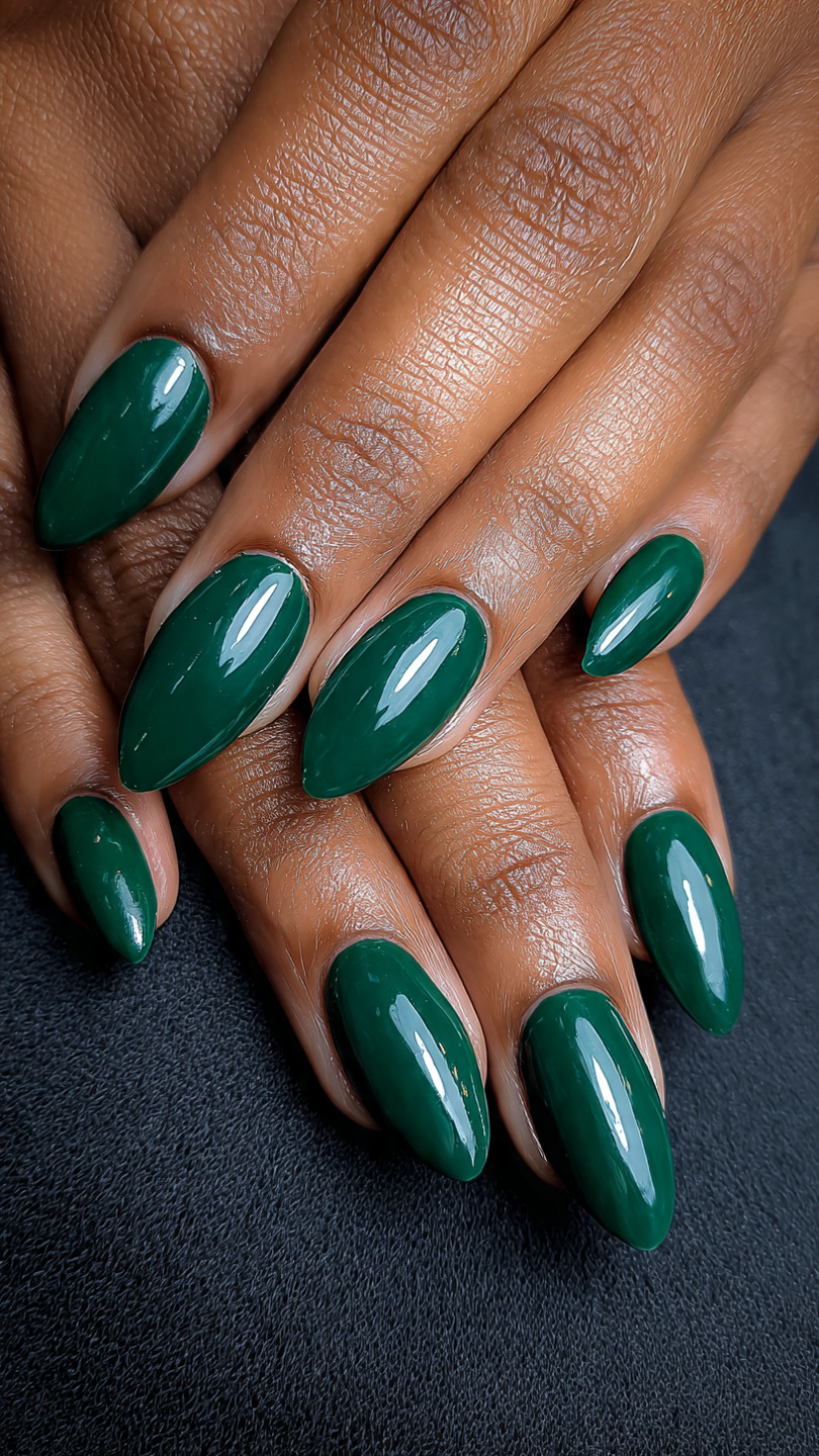 Almond-shaped nails in glossy emerald green polish