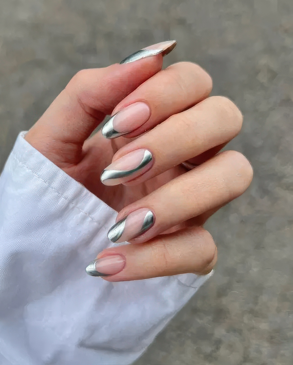 Silver chrome swirls on nude almond nails