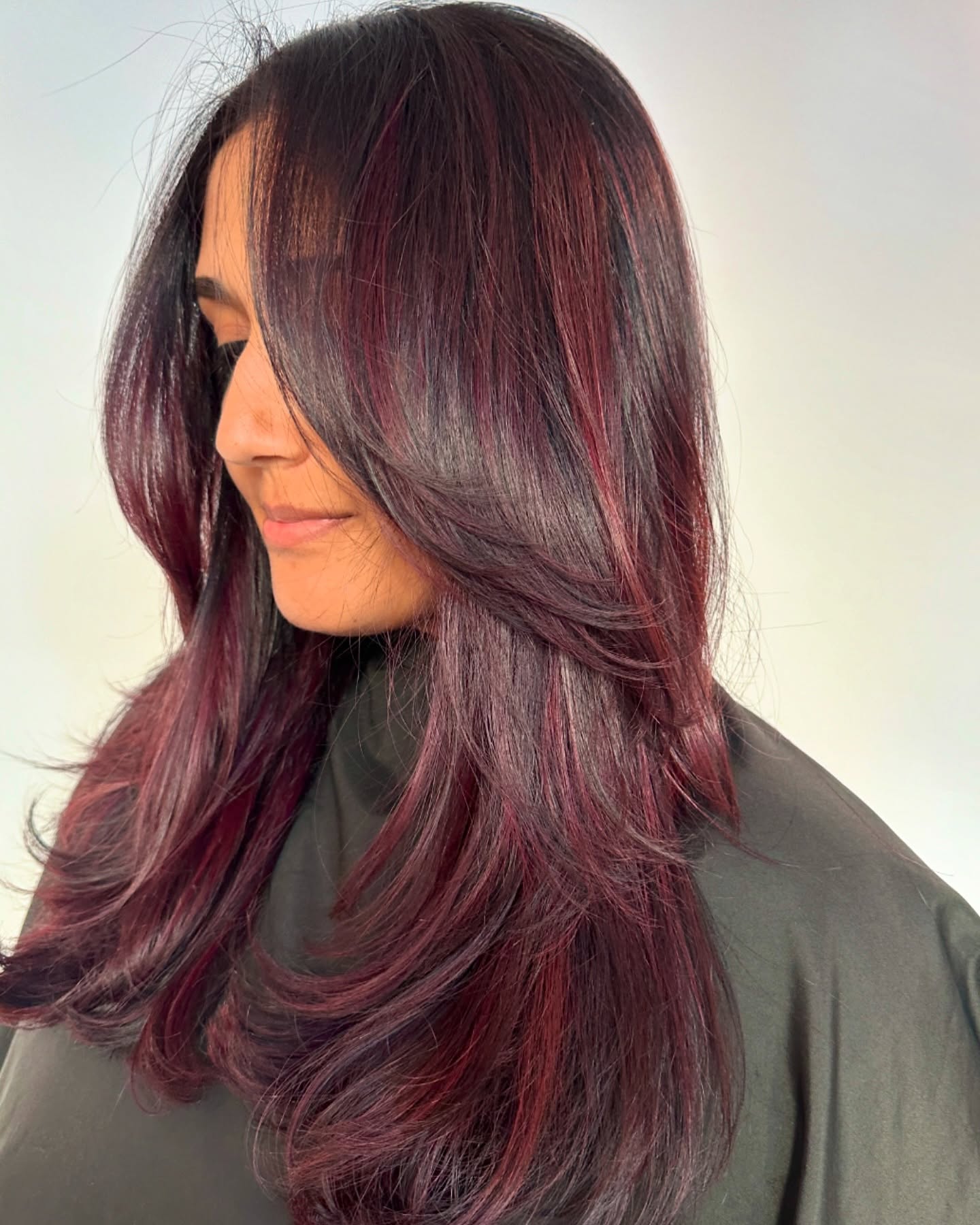 Long layered cherry cola hair with brighter face-framing pieces