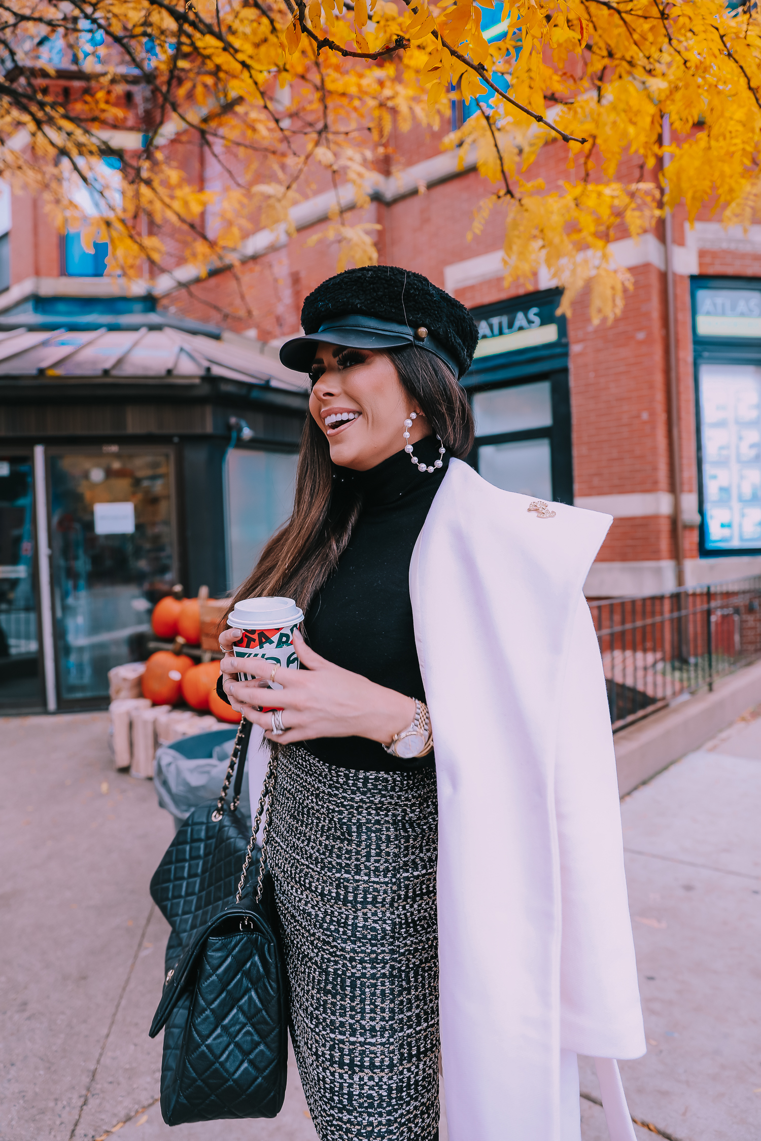 Black turtleneck with a black-and-white tweed mini skirt and quilted chain bag