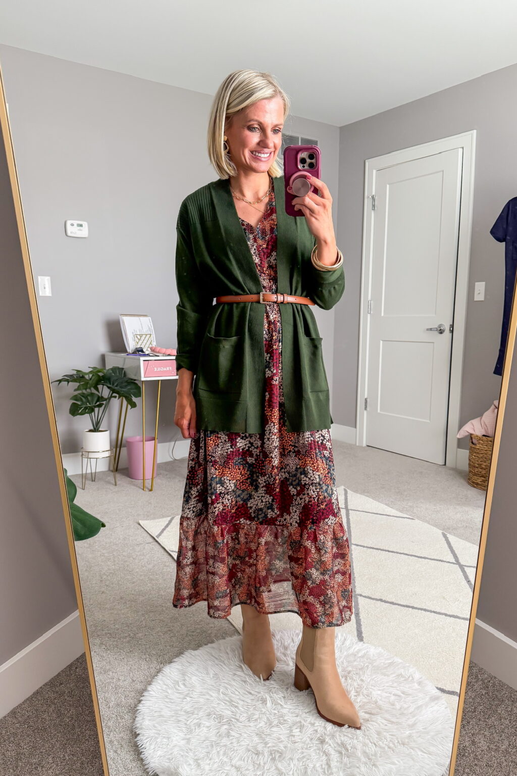 Open knit cardigan layered over a midi dress with ankle boots