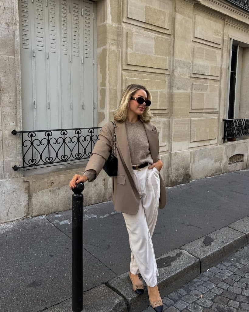 Woman wearing a taupe blazer with cream wide-leg trousers on a Paris street