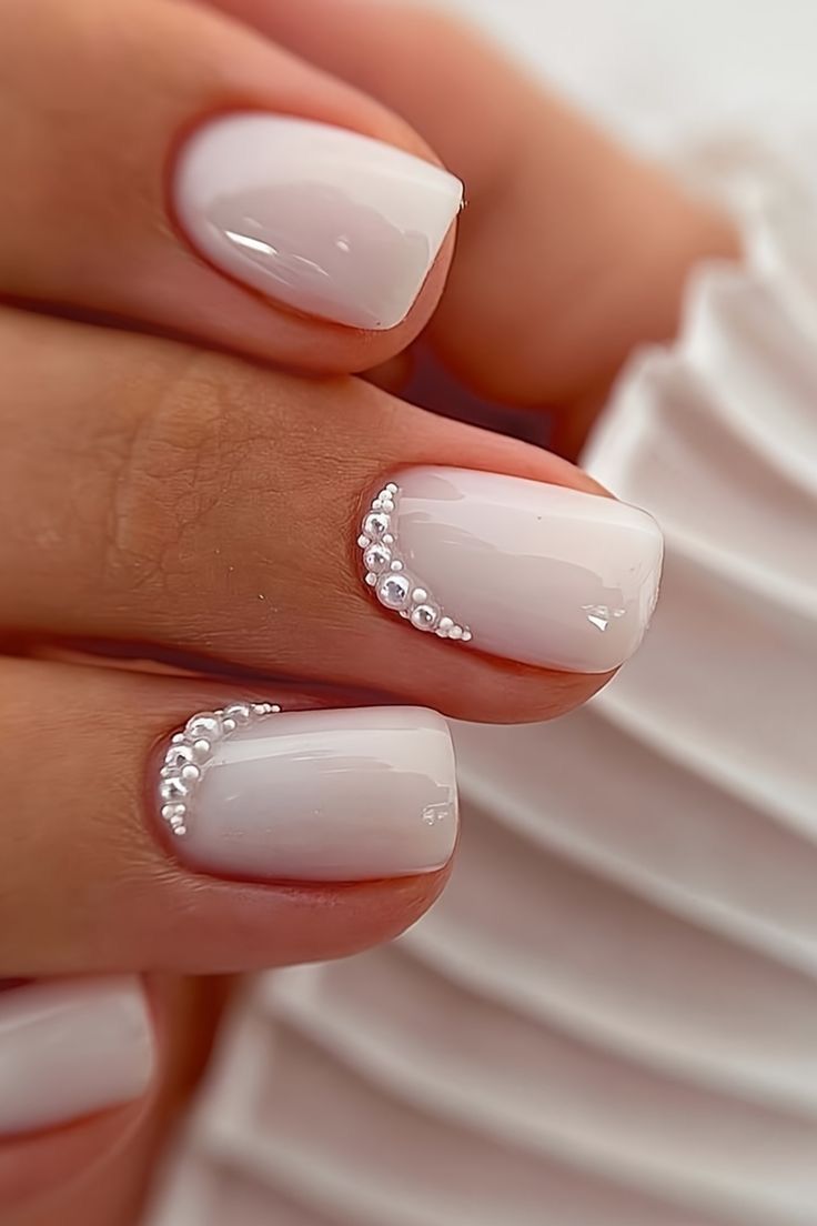 White pearl-finish nails decorated with rhinestones