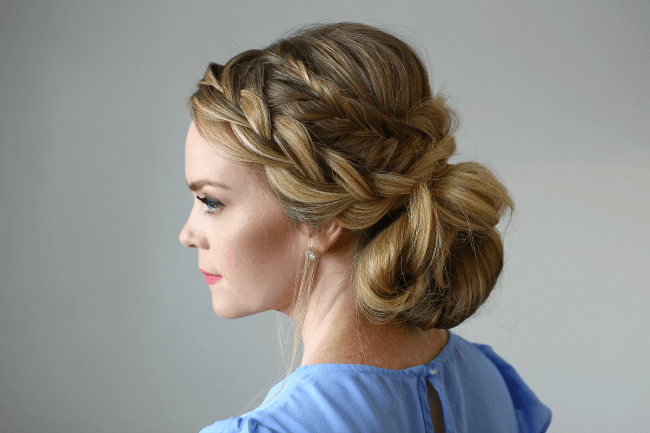 Side profile of a fishtail french braid leading into a low messy bun
